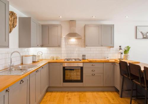 a kitchen with white cabinets and a sink at Discovery Barn - Luxury 2 Bed Barn Conversion! in Cropthorne