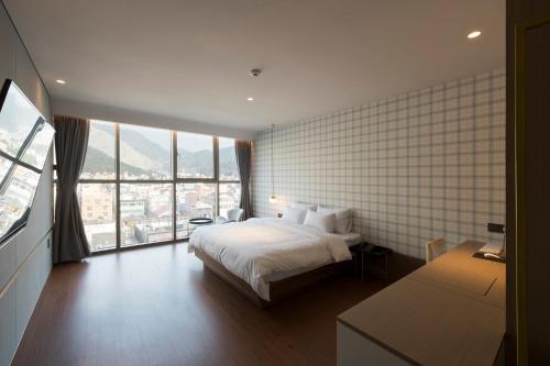 a hotel room with a bed and a large window at Hound Hotel Changwon Jinhae in Changwon