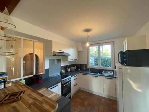 une cuisine avec un réfrigérateur blanc et une table dans l'établissement Duplex spacieux 8 pers avec terrasse et parking, Capbreton - FR-1-413-249, à Capbreton