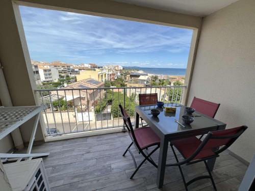 une table et des chaises sur un balcon avec vue sur l'océan dans l'établissement Studio avec Piscine, Parking, Clim, Plage à 50m - FR-1-702-69, au Cap d'Agde