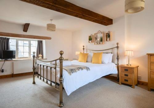 a bedroom with a large bed and a television at Diston's Lane - Beautiful 2BD Home, Perfect For Family Retreat! in Chipping Norton