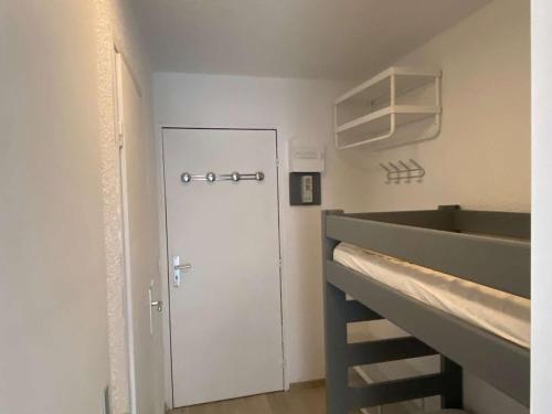 Cette chambre dispose d'un escalier menant à une porte blanche. dans l'établissement Coquet studio coeur station pour 4, proche commerces et pistes - FR-1-322-655, aux Orres