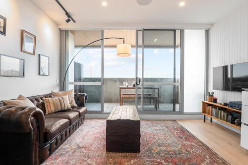 ein Wohnzimmer mit Couch und Tisch in der Unterkunft Artist Abode: Stay in a Home That’s Also a Gallery in Melbourne
