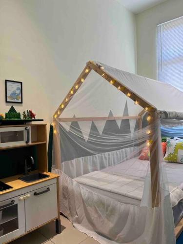 a bedroom with a canopy bed with lights on it at Stylaa Homestay Kedah in Kampong Guar Nanas