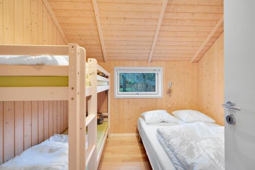 two bunk beds in a tiny house with a window at Stunning Home In Rønde With 3 Bedrooms And Wifi in Rønde