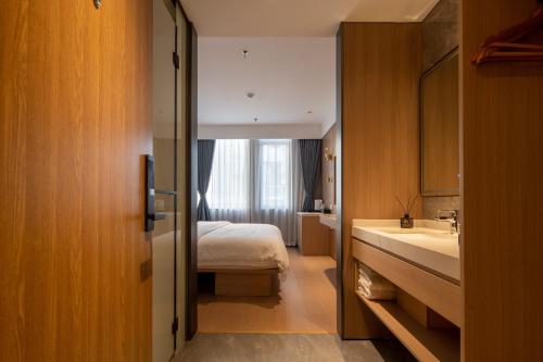 a bathroom with a bed and a sink in a room at Dayin Garden Hotel -People's Square & Nanjing Road-Large Social Area -Bar -Café -Gym -Free Laundry Luggage Storage -24H Front Desk-English Service in Shanghai