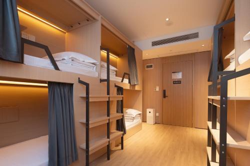 a dorm room with bunk beds and a hallway at Dayin Garden Hotel -People's Square & Nanjing Road-Large Social Area -Bar -Café -Gym -Free Laundry Luggage Storage -24H Front Desk-English Service in Shanghai