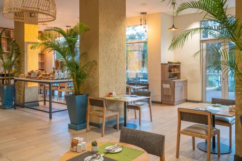 a restaurant with tables and chairs and palm trees at Holiday Inn - Lusaka by IHG in Lusaka