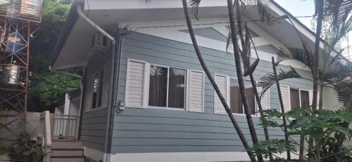 a blue and white house with a porch at Tiny house in city proper in Puerto Princesa City