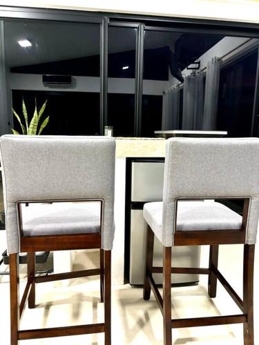 two chairs sitting next to a counter in a kitchen at Cabaña con piscina y vista al mar in Puntarenas