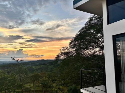 a view of a sunset from the balcony of a house at Cabaña con piscina y vista al mar in Puntarenas