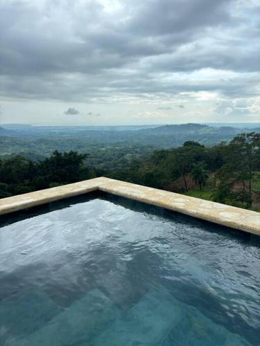 a swimming pool with a view of the forest at Cabaña con piscina y vista al mar in Puntarenas