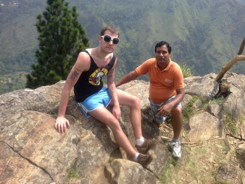 two men sitting on some rocks on a mountain at Anura Home Stay in Kalutara
