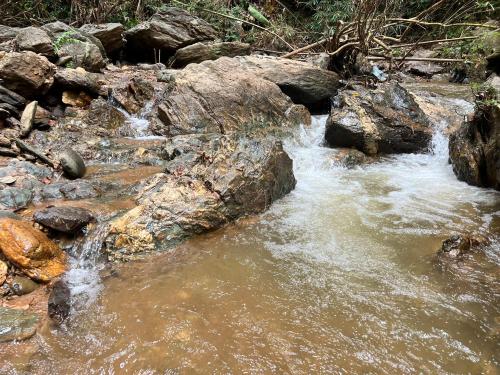 a stream of water with rocks in a river at บ้านไร่ไอดอย in Phrae