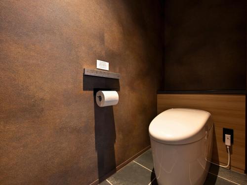 a bathroom with a toilet and a roll of toilet paper at Kobe Suma Seaworld Hotel in Kobe