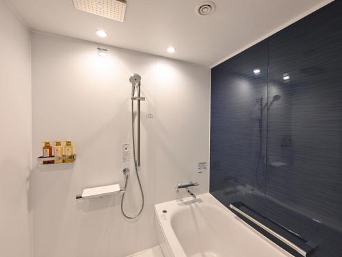 a bathroom with a shower and a bath tub at Kobe Suma Seaworld Hotel in Kobe