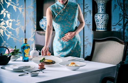 a woman standing next to a table with plates of food at Grand InterContinental Seoul Parnas by IHG in Seoul
