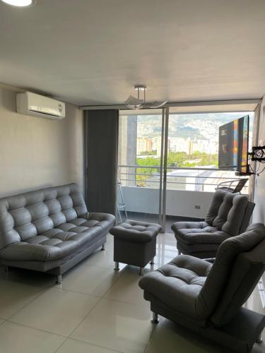 a living room with couches and chairs and a large window at Ivanna Jumar ApartaHotel in Medellín