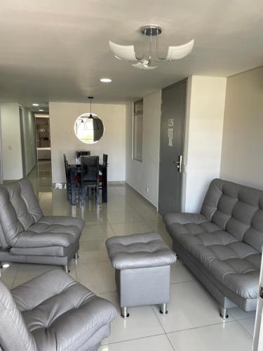 a living room with couches and a dining room at Ivanna Jumar ApartaHotel in Medellín