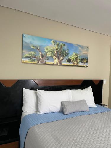 a bedroom with a bed with a painting on the wall at Ivanna Jumar ApartaHotel in Medellín