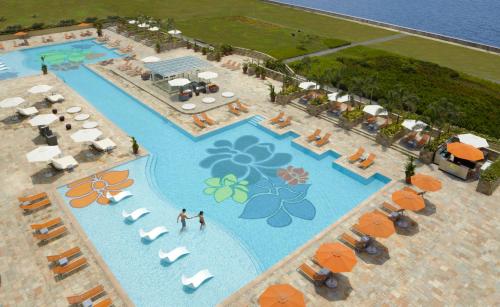 an aerial view of a resort pool with umbrellas and chairs at Solaire Resort Entertainment City in Manila