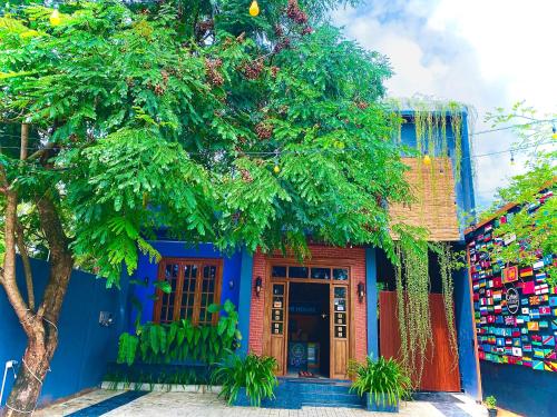 a blue house with a tree in front of it at Coffee House Dambulla in Dambulla