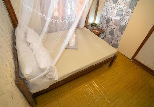 a bed in a room with a mosquito net at Femya Homestay in El Nido
