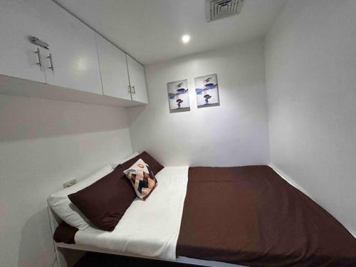 a small white room with a bed in it at ACL Staycation A private house with swimming pool- Unit1 in Kawit
