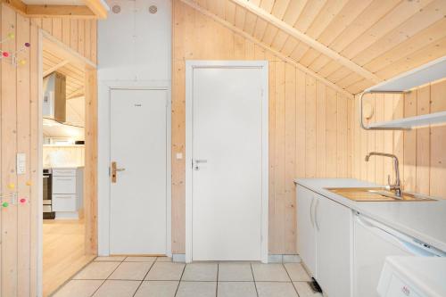 a kitchen with wooden walls and a white door at Stunning Home In Rønde With 3 Bedrooms And Wifi in Rønde