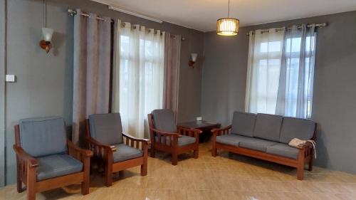 a waiting room with chairs and a table and windows at Villa Jehan Tourist Residence in Souillac