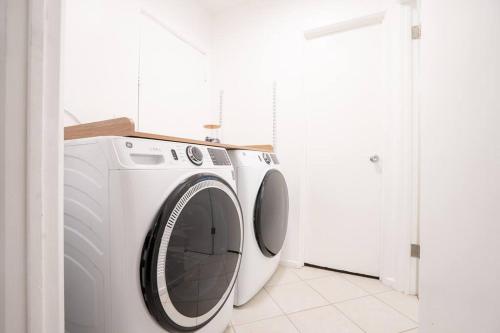 a white washing machine in a white laundry room at Stylish Cozy, Aesthetic, Stocked Kitchen, and Pet Friendly in Palmdale