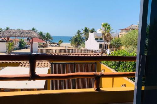 a balcony with a view of a beach and the ocean at Casa Hipocampo a pasos de la playa in Ixtapa-Zihuatanejo International