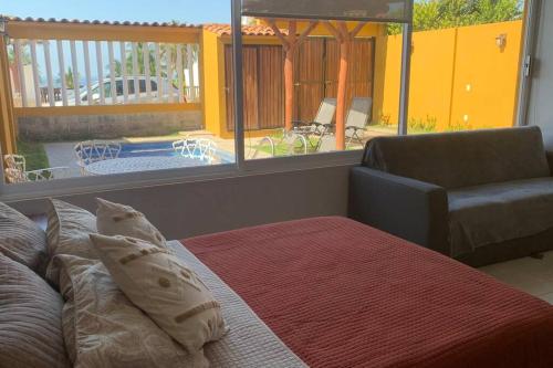 a bedroom with a bed and a couch and a patio at Casa Hipocampo a pasos de la playa in Ixtapa-Zihuatanejo International