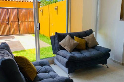 a blue couch with pillows sitting in a living room at Casa Hipocampo a pasos de la playa in Ixtapa-Zihuatanejo International
