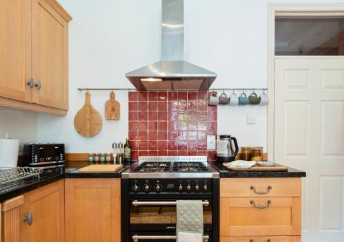 a kitchen with a stove top oven in a kitchen at Gorgeous 3BD in Oxfordshire - Stunning Countryside! in Steeple Aston