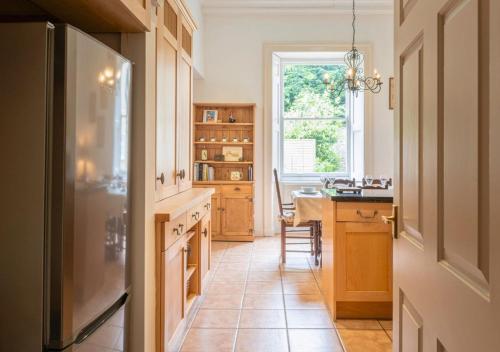 a kitchen with a refrigerator and a table and a window at Gorgeous 3BD in Oxfordshire - Stunning Countryside! in Steeple Aston