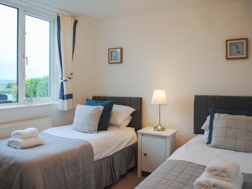 Un dormitorio con dos camas y una ventana. en Fairview, en Salcombe