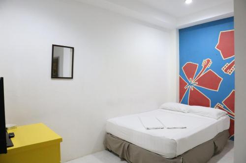 a bedroom with a bed with a painting on the wall at Island Inn in Boracay