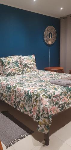 a bedroom with a bed with a blanket and a fan at Rose Maison in Pirae