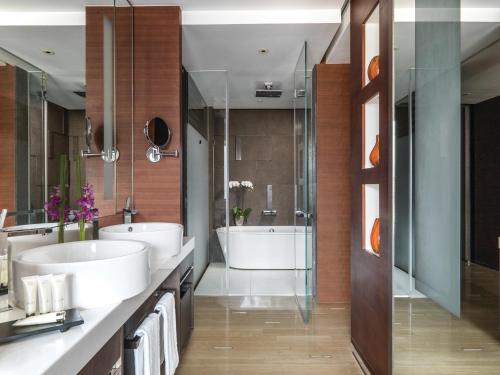 a bathroom with a tub, sink and mirror at The Langham, Shanghai, Xintiandi in Shanghai