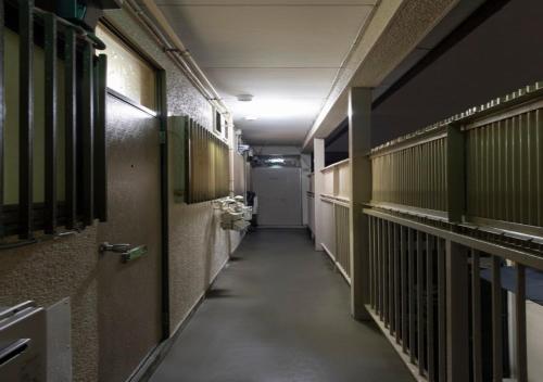 a hallway of a prison cell with a long corridor at apartment hotel myu 宇都宮 in Utsunomiya