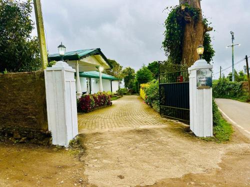a driveway with a gate and a house at Silver Meir Bungalow in Nuwara Eliya