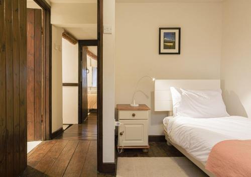 a bedroom with a bed and a table with a lamp at Honeypot Cottage - Charming Bolthole in Stow! in Stow on the Wold