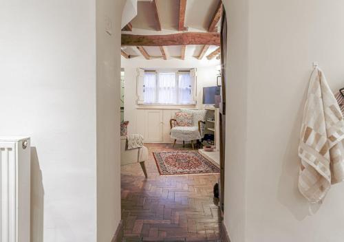 a hallway leading to a living room with a ceiling at Honeypot Cottage - Charming Bolthole in Stow! in Stow on the Wold