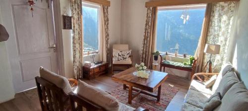 a living room with a couch and a table at Katie's Abode, Hartola in Rāmgarh