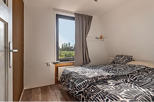 two beds in a room with a window at Het Cosy Room in Sluiskil