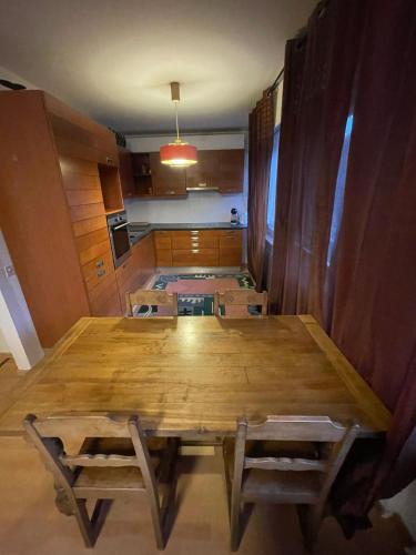 a dining room with a large wooden table and chairs at Les Nis in Bourg-Saint-Pierre