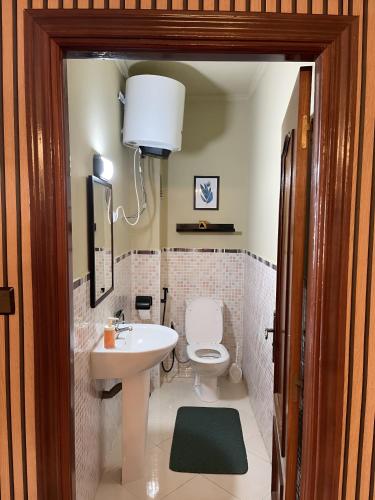 a bathroom with a white toilet and a sink at Cozy Flat With Sea View in Tangier