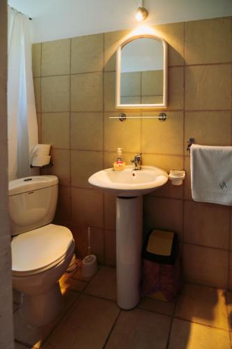 a bathroom with a toilet and a sink at AlmaVille Mamaia in Mamaia Sat/Năvodari