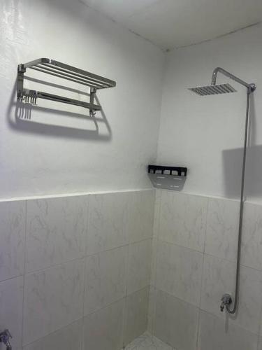 a bathroom with a shower and a white wall at ACL Staycation Home in Imus & Kawit with portable pool unit 2 in Kawit